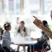 a lady pointing to a world map