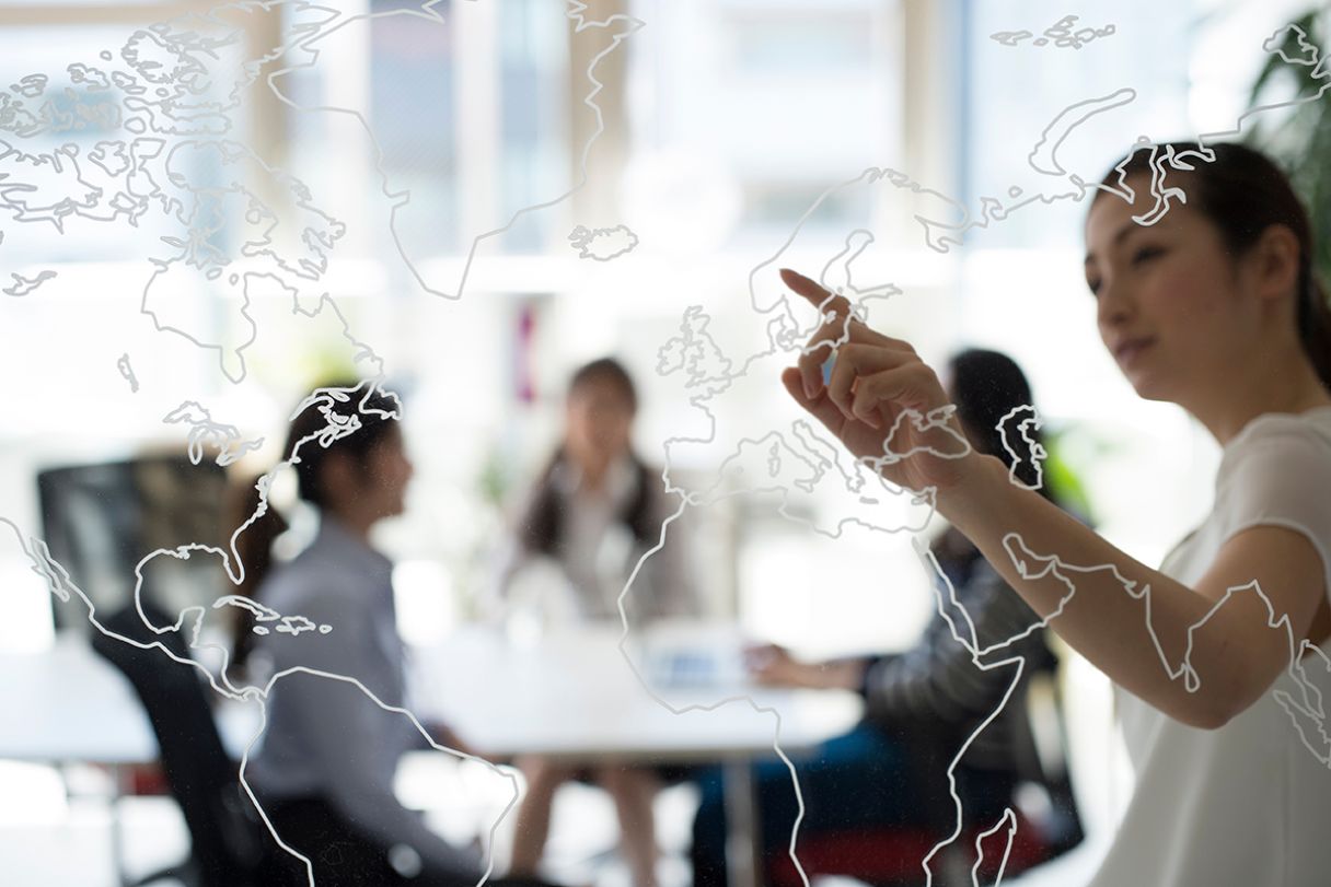 a lady pointing to a world map