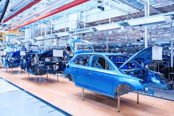A production line of blue cars being assembled