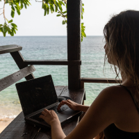 Digital nomad woman working on the beach