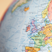 A closeup of Europe on the globe against a yellow background
