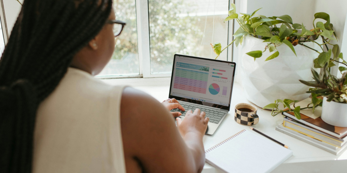 An over-the-shoulder look at a woman working at her desk