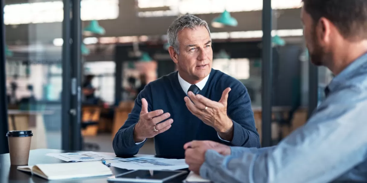 Senior male payroll professional talking to colleague